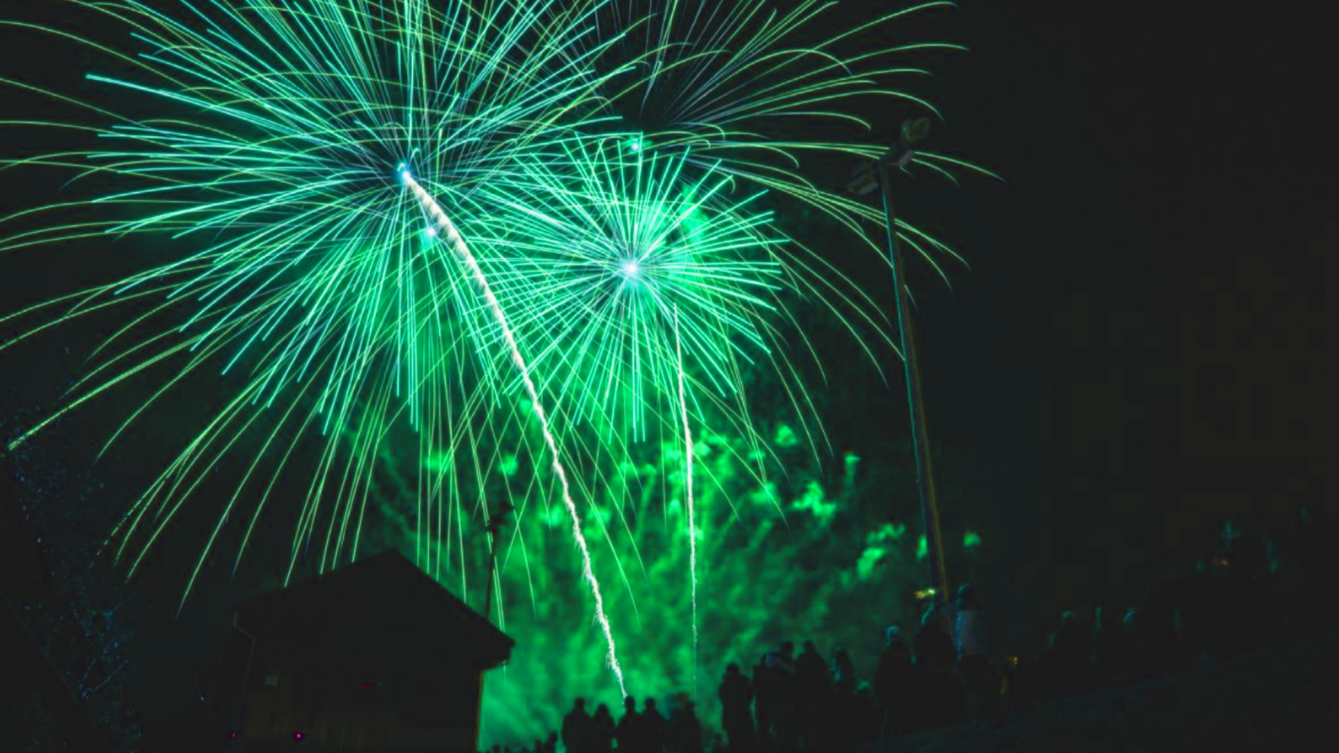 Grönfärgat fyrverkeri mot svart himmel