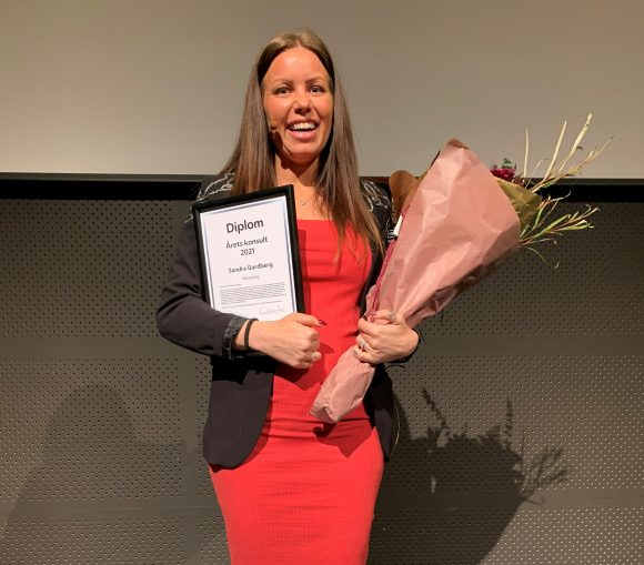 Sandra Gardberg, Årets konsult 2021 ler stort och håller i blommor och priser