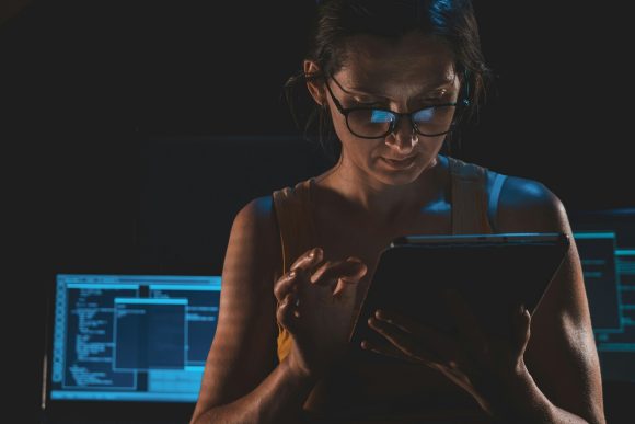 Kvinna arbetar vid dator med fokus på att hantera en cyberincident.